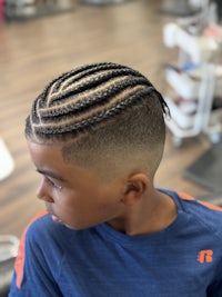 a young boy with braided hair in a salon