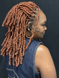 a woman with red dreadlocks wearing a headset